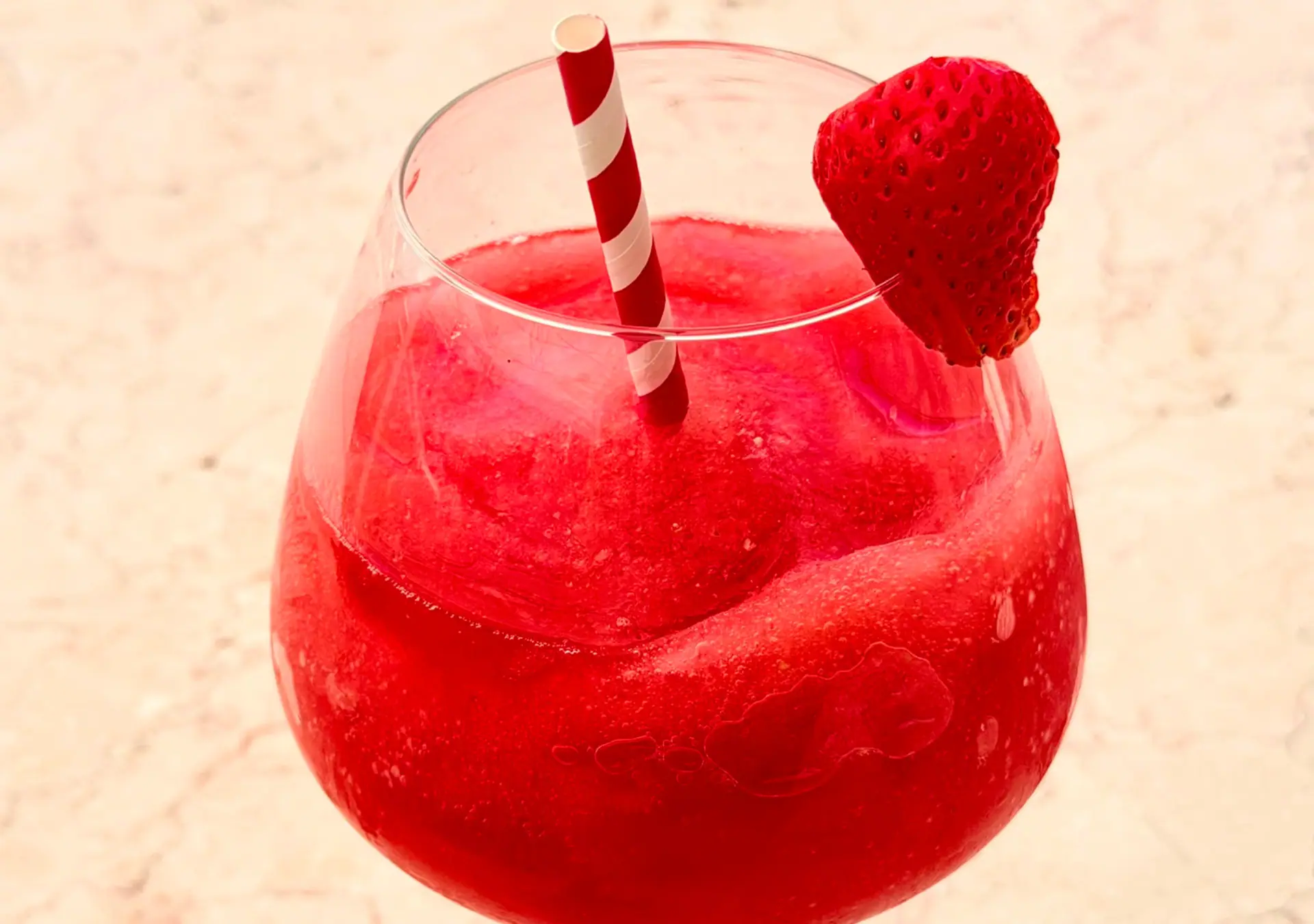 A frozen strawberry daiquiri with a strawberry garnish at Zazoo