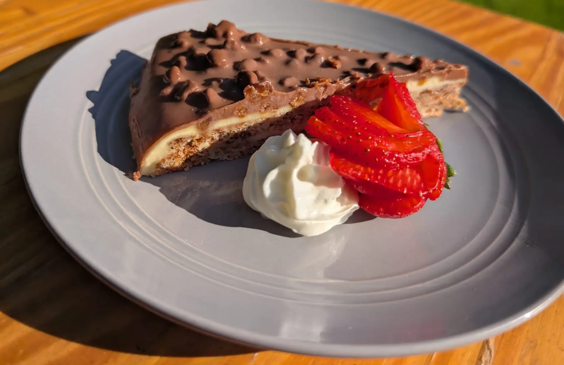 A slice of chocolate biscuit cake with fresh strawberries and cream at Zazoo