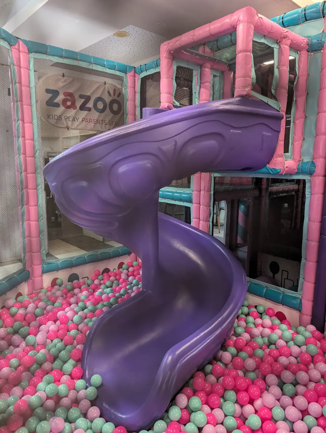 The purple spiral slide corkscrewing down into Zazoo's pink and mint ball pit