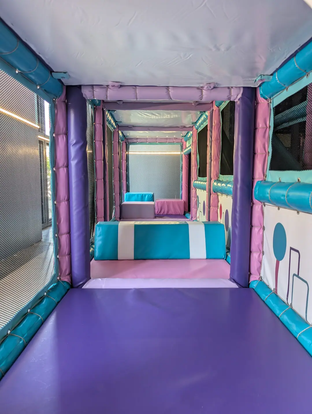 A padded tunnel through Zazoo's soft play frame with blue and pink foam blocks to clamber over